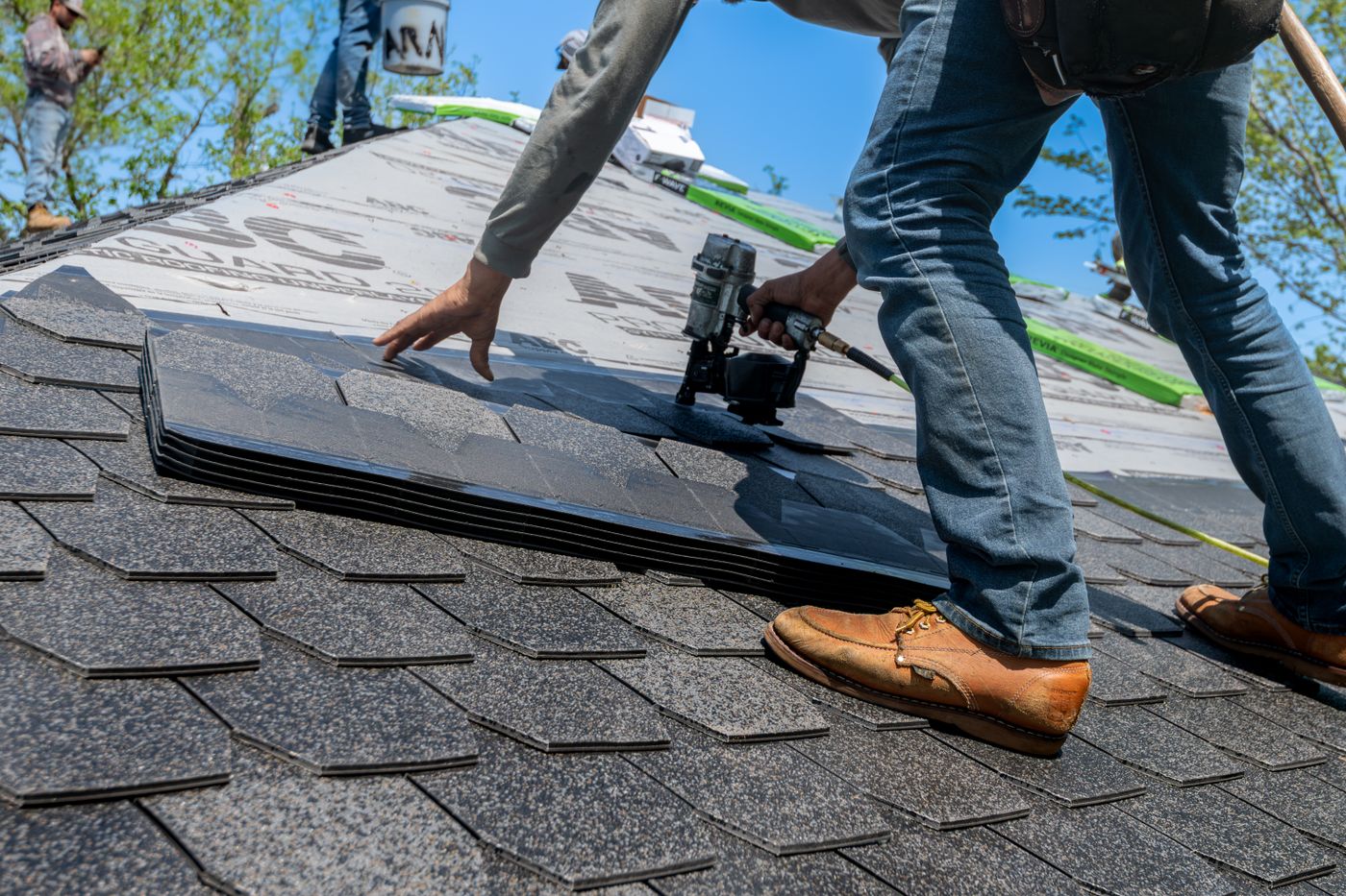 Roofer installing shingles